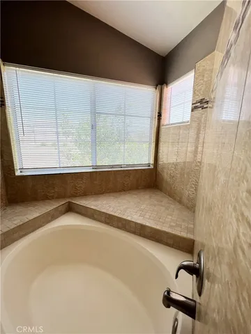 a bathroom with a granite countertop sink and a bathtub