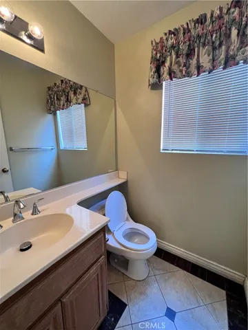 a bathroom with a sink mirror vanity and toilet