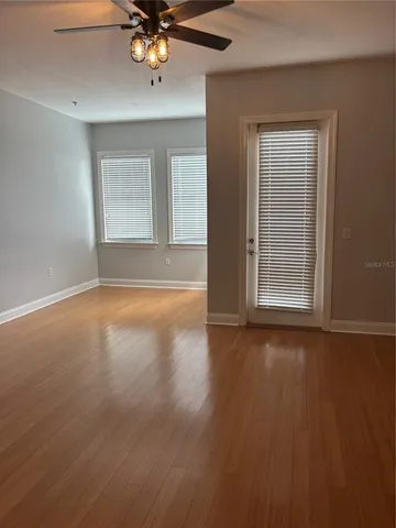 a view of wooden floor and a chandelier fan in a room
