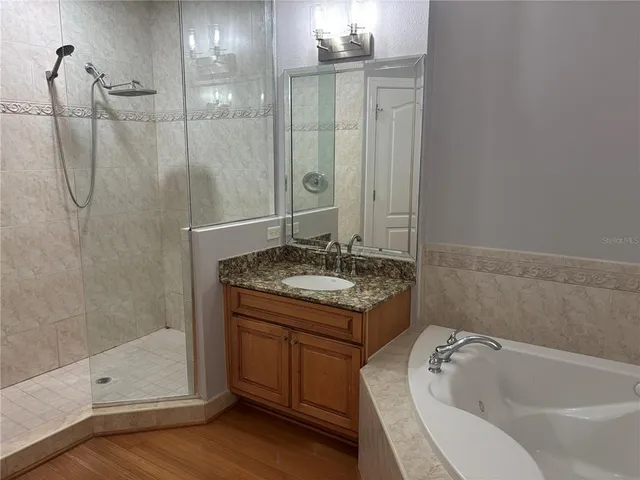 a bathroom with a granite countertop sink a toilet and shower