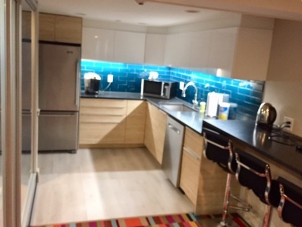 292 Beacon Street, Unit 1 2 Somerville, MA 02143 - Photo 11 of 27 a kitchen with stainless steel appliances kitchen island granite countertop a refrigerator and a sink