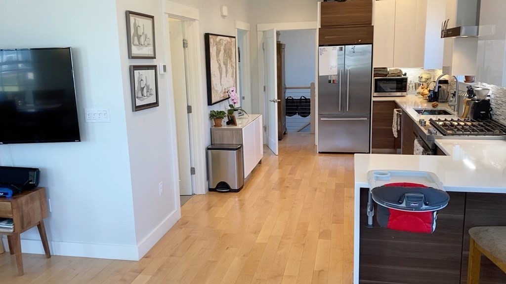 292 Beacon Street, Unit 1 2 Somerville, MA 02143 - Photo 17 of 27 a kitchen with stainless steel appliances kitchen island granite countertop a refrigerator and a stove