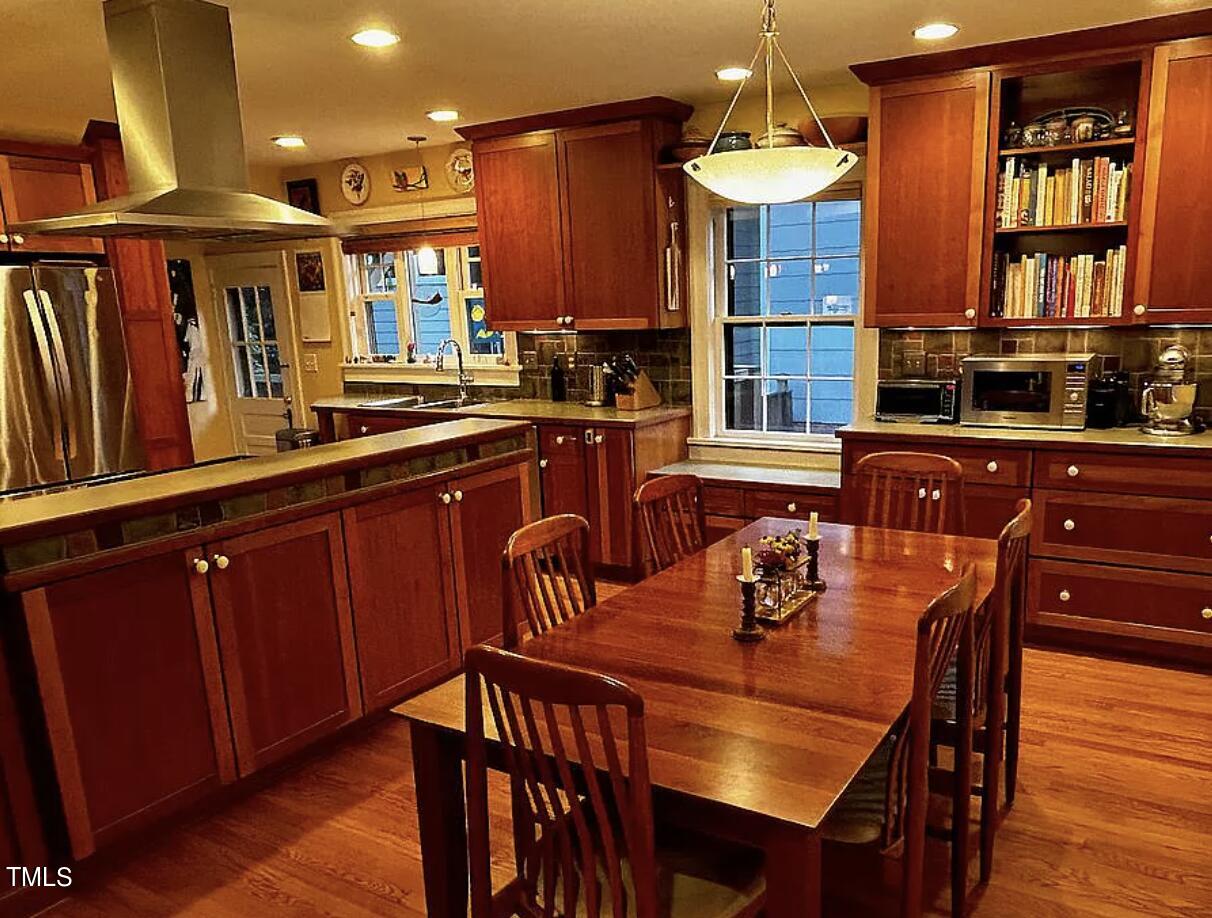 309 Perry Street Raleigh, NC 27608 - Photo 3 of 4 a kitchen with stainless steel appliances granite countertop a table chairs and a refrigerator