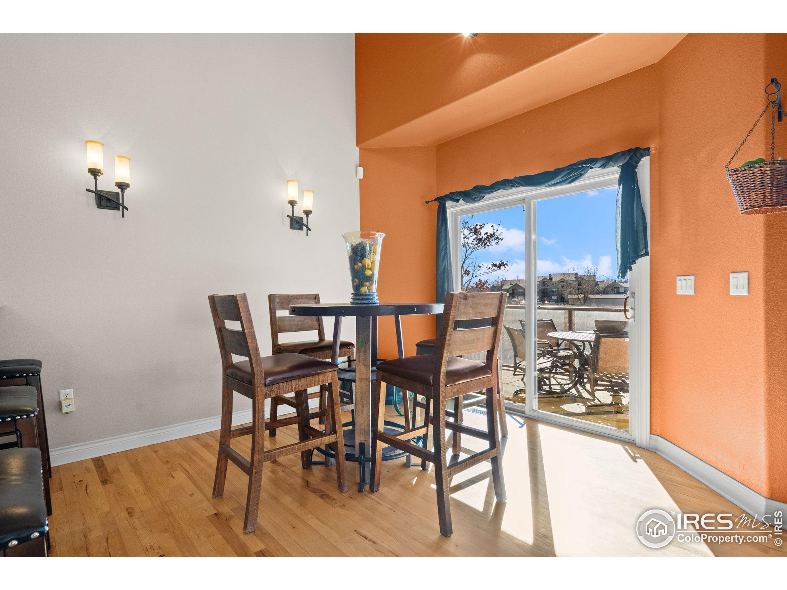621 Roma Valley Drive Fort Collins, CO 80525 - Photo 12 of 50 a view of a dining room with furniture and wooden floor