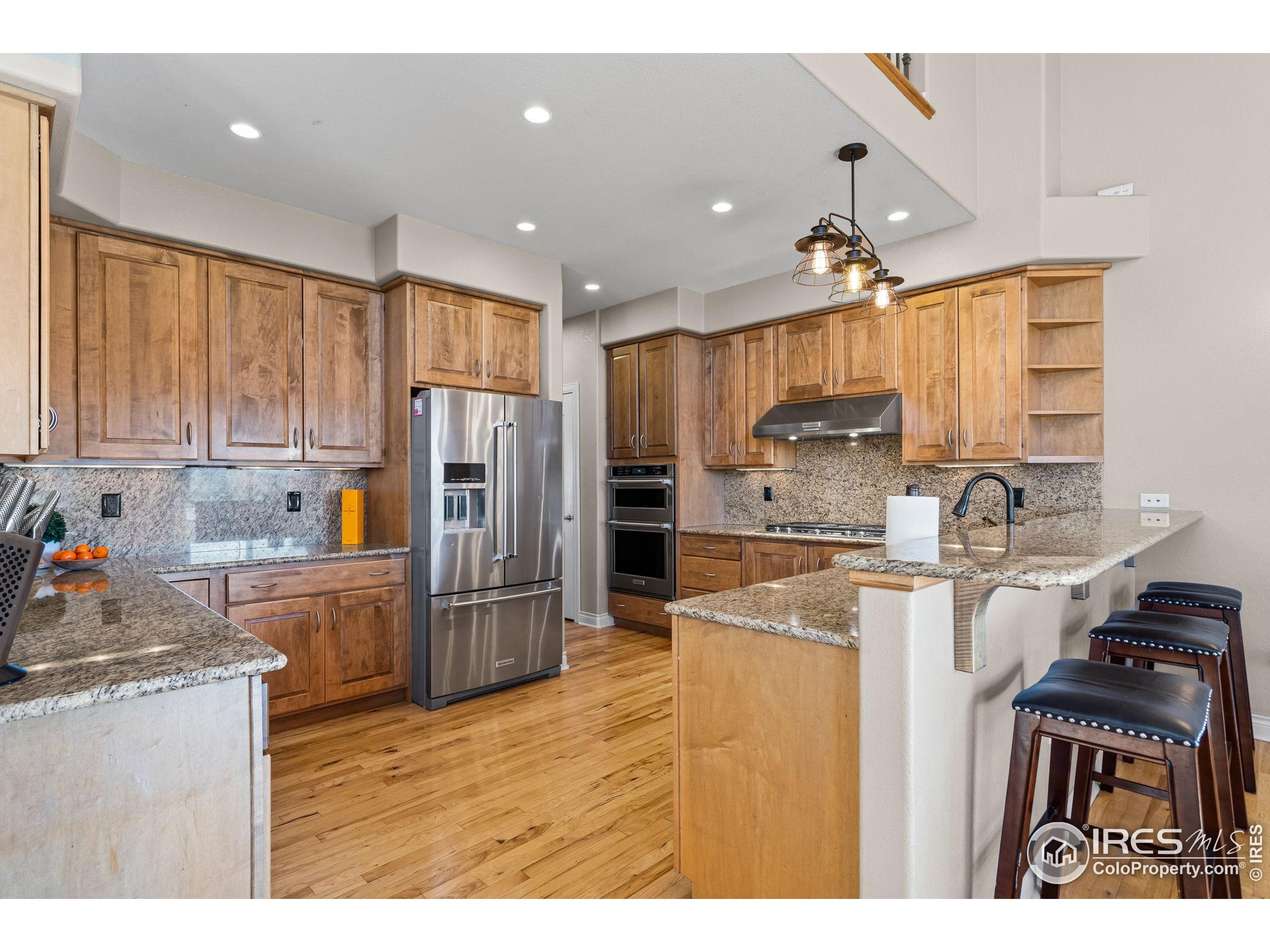 621 Roma Valley Drive Fort Collins, CO 80525 - Photo 15 of 50 a kitchen with refrigerator cabinets and wooden floor