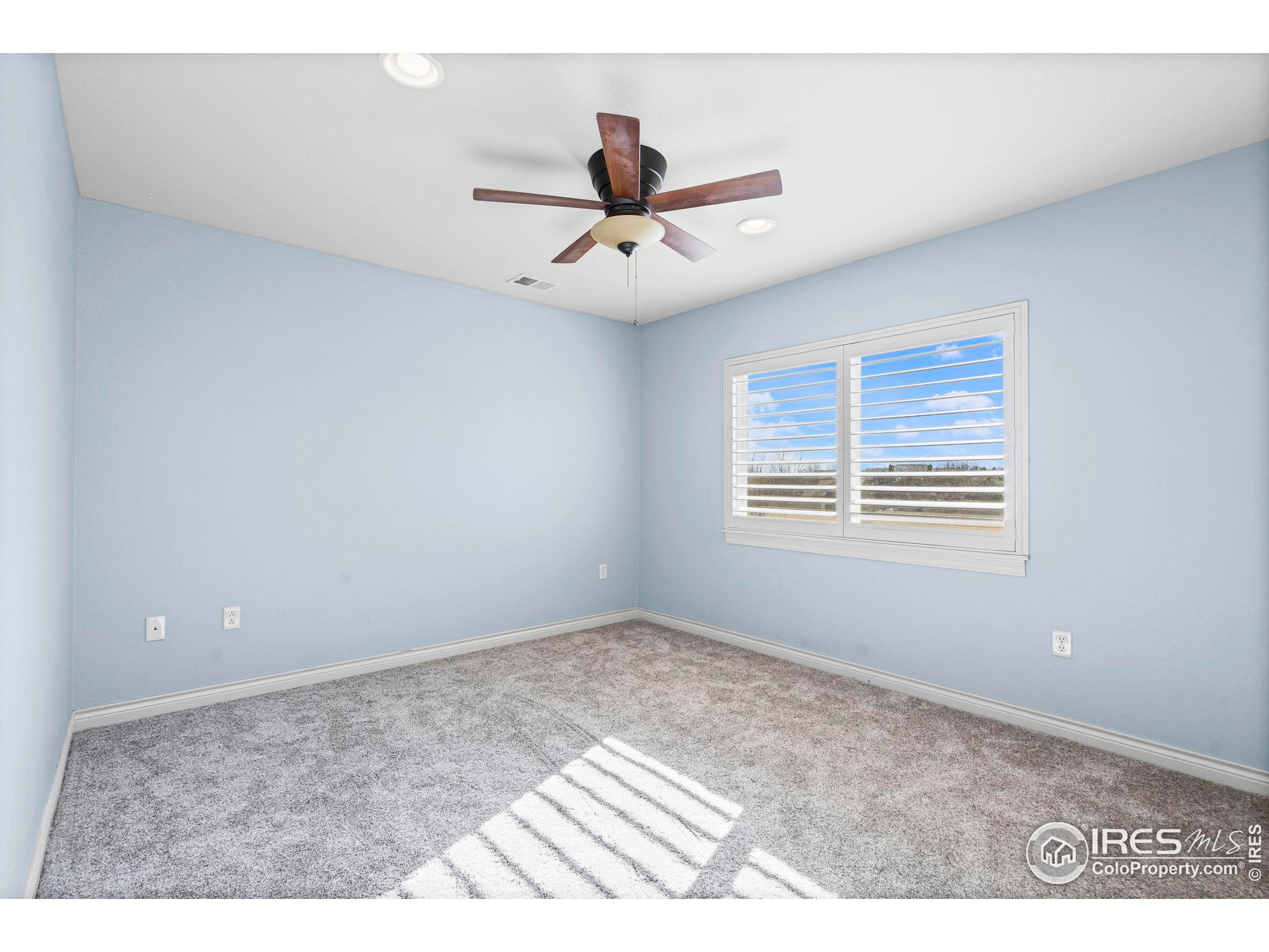 621 Roma Valley Drive Fort Collins, CO 80525 - Photo 32 of 50 a view of an empty room with a ceiling fan and a window