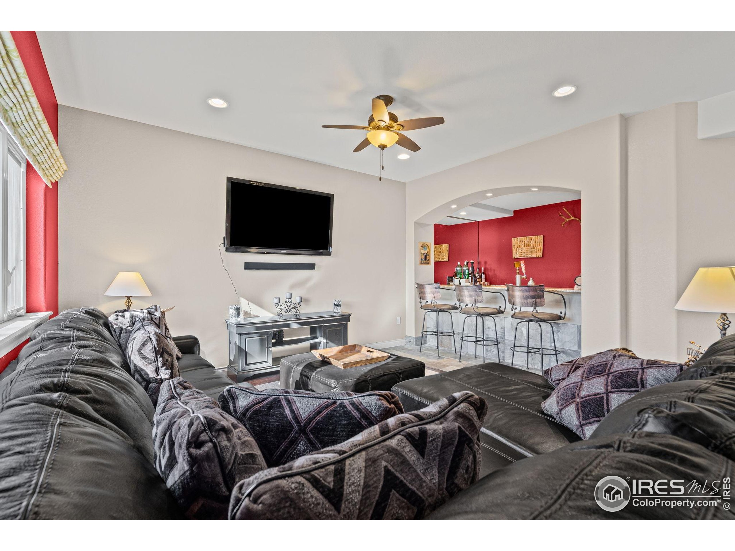 621 Roma Valley Drive Fort Collins, CO 80525 - Photo 38 of 50 a living room with furniture and a flat screen tv