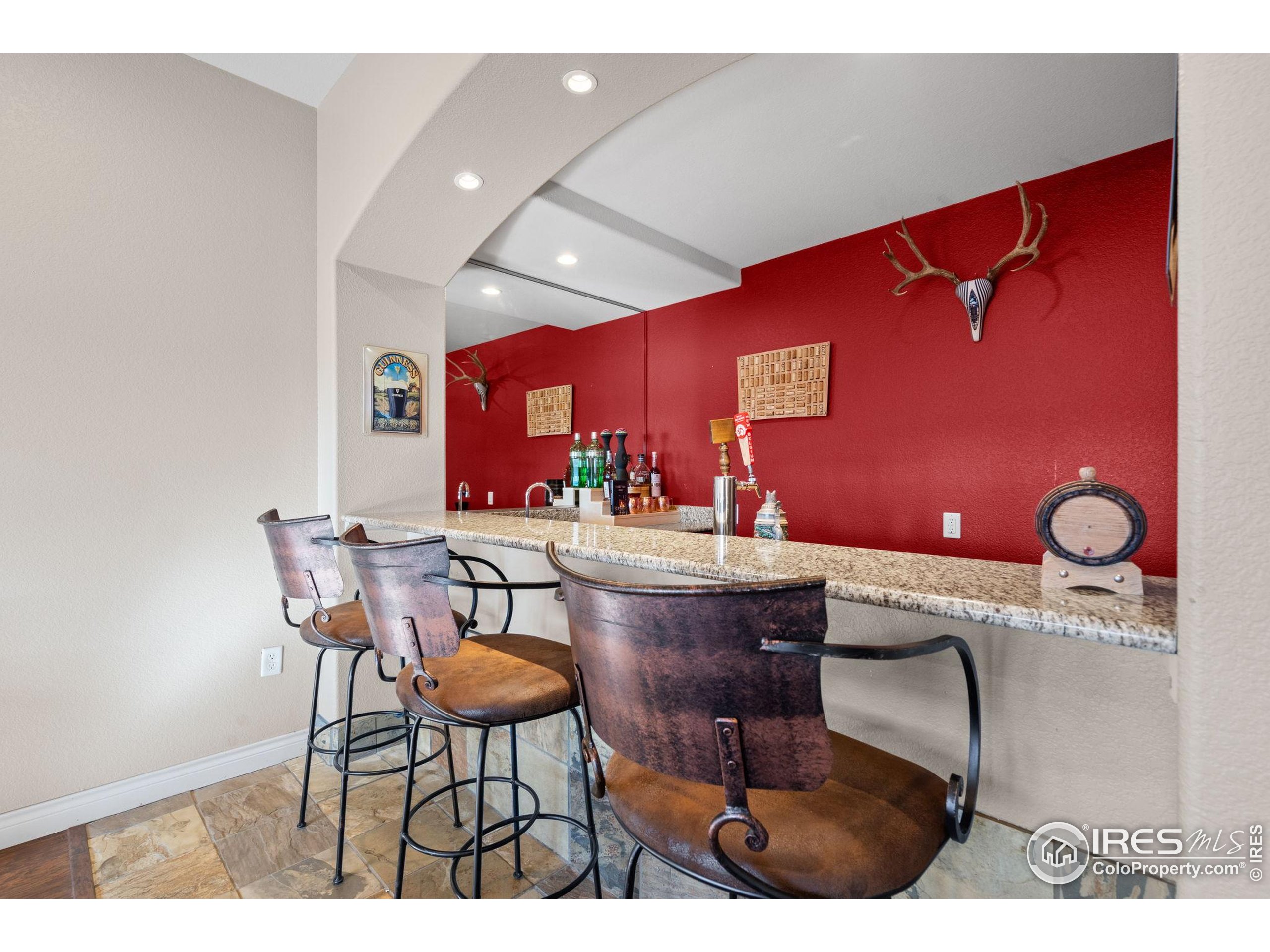 621 Roma Valley Drive Fort Collins, CO 80525 - Photo 39 of 50 a kitchen with stainless steel appliances kitchen island granite countertop a dining table chairs and a refrigerator