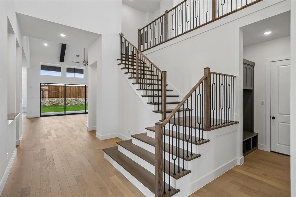 1120 Whirlabout Road Prosper, TX 75078 - Photo 3 of 25 Offering sight lines from the front through to the rear of the home and an elegant warp around staircase with stylish railings and wood treads, this stunning entry area provides the perfect space to welcome family and friends!