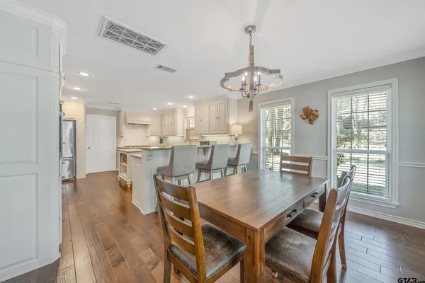a kitchen with granite countertop a sink a stove a counter space and cabinets