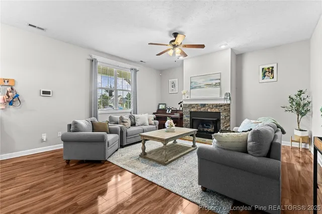 a living room with furniture a fireplace and a large window