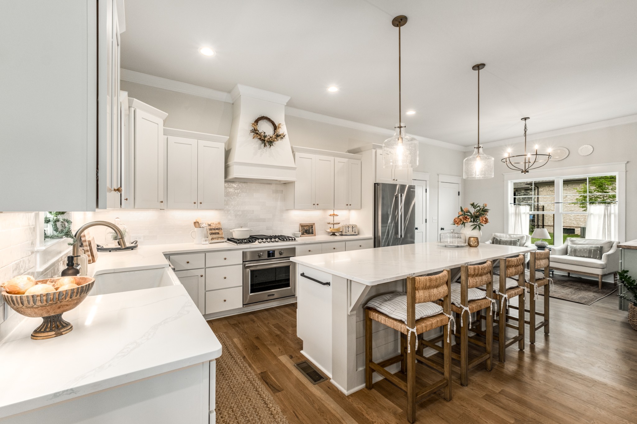 9011 Safehaven Place Spring Hill, TN 37174 - Photo 26 of 84 a kitchen with stainless steel appliances kitchen island granite countertop a sink a stove a dining table chairs and white cabinets