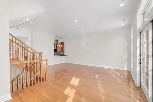 a view of a hallway with wooden floor and windows