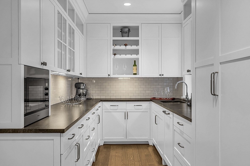 403 Simon Willard Road Concord, MA 01742 - Photo 18 of 42 a kitchen with granite countertop white cabinets and stainless steel appliances