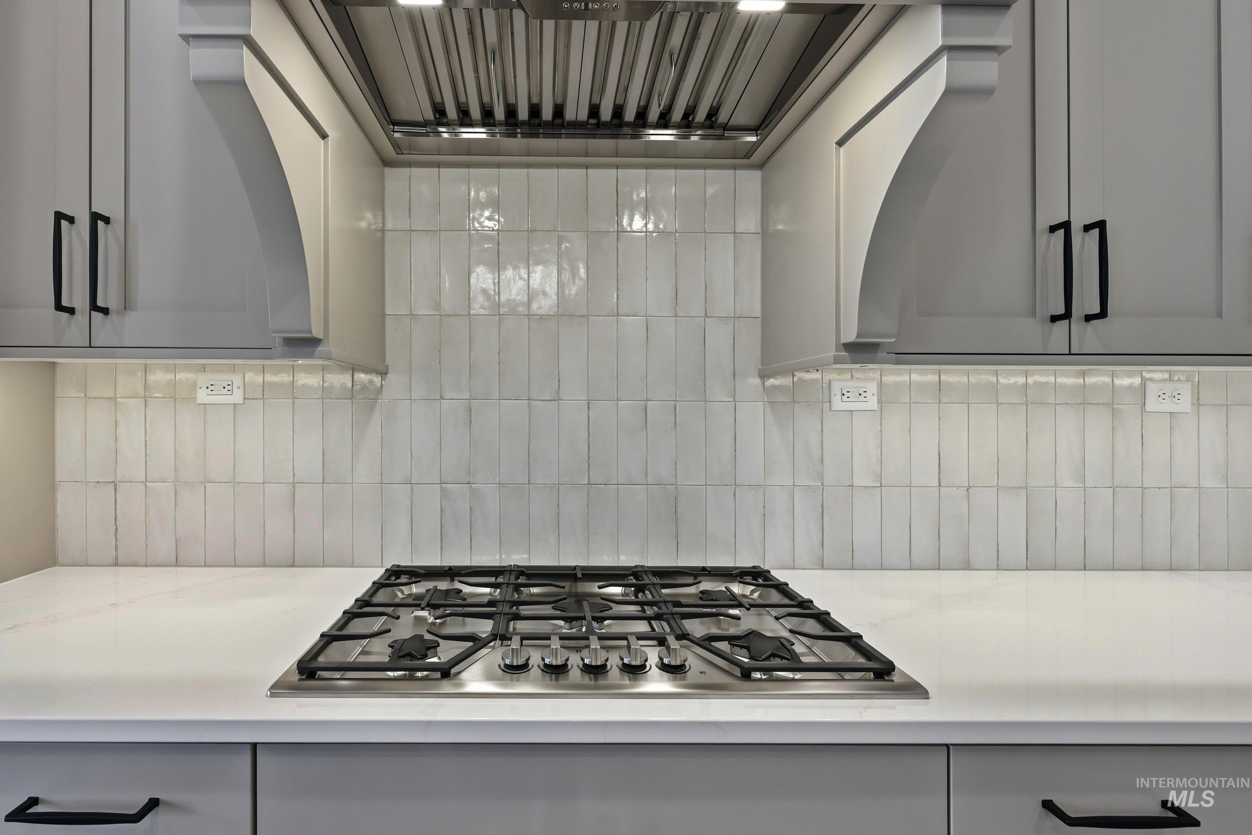 1048 East Escalation Street Meridian, ID 83642 - Photo 11 of 44 Kitchen with exhaust hood, stainless steel gas stovetop, gray cabinetry, and tasteful backsplash