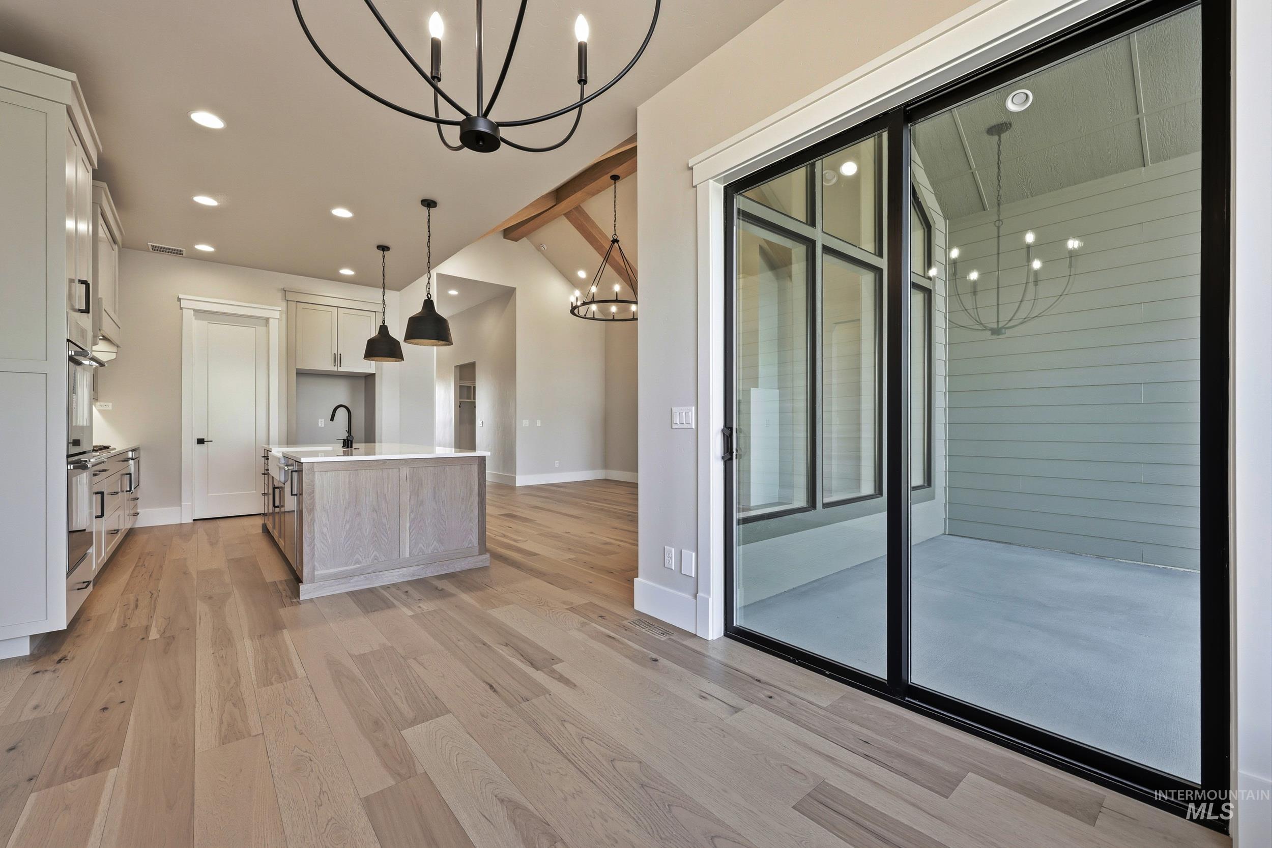 1048 East Escalation Street Meridian, ID 83642 - Photo 13 of 44 Kitchen with a chandelier, recessed lighting, an island with sink, pendant lighting, and lofted ceiling