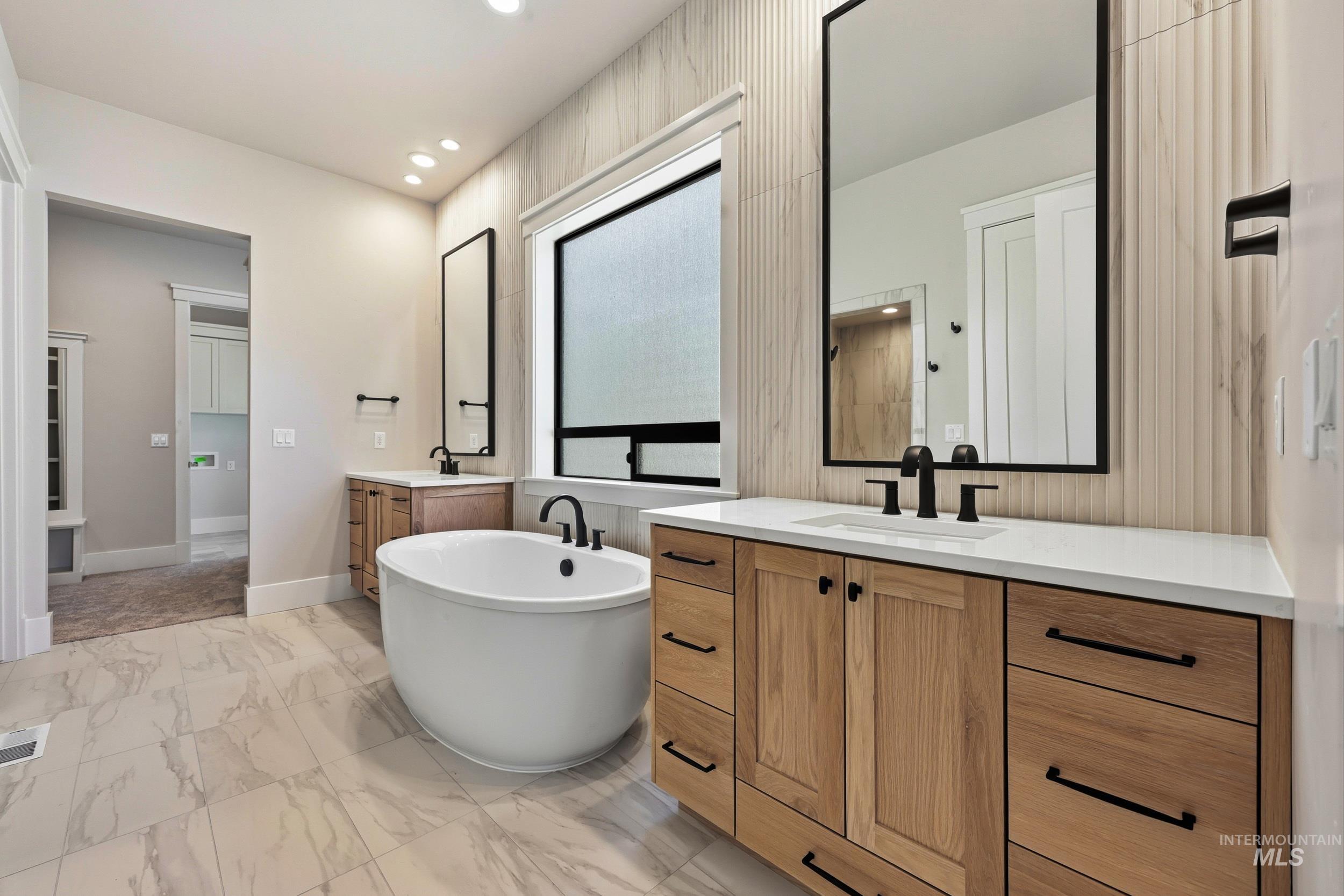 1048 East Escalation Street Meridian, ID 83642 - Photo 19 of 44 Full bath featuring a freestanding tub, light marble finish floors, two vanities, and recessed lighting