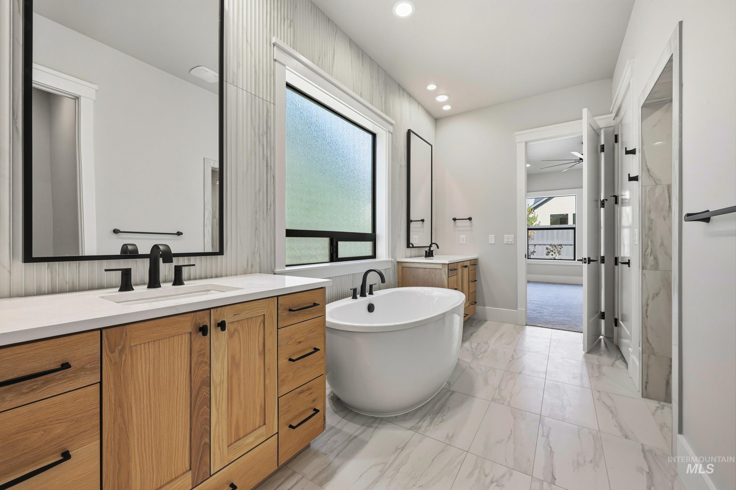 1048 East Escalation Street Meridian, ID 83642 - Photo 24 of 44 Full bath with two vanities, a freestanding tub, light marble finish floors, recessed lighting, and ceiling fan