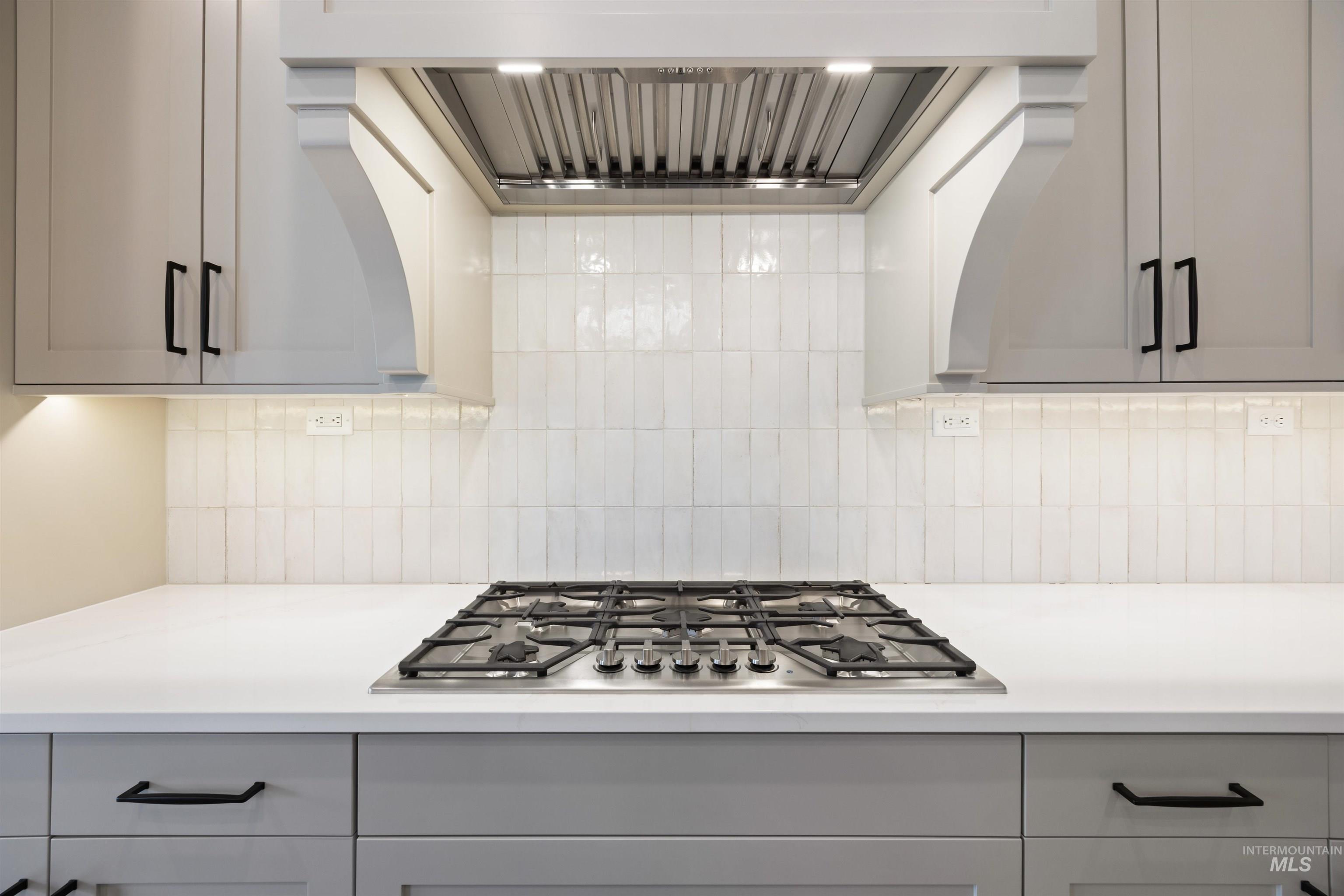 1048 East Escalation Street Meridian, ID 83642 - Photo 25 of 44 Kitchen featuring extractor fan, stainless steel gas cooktop, and gray cabinetry