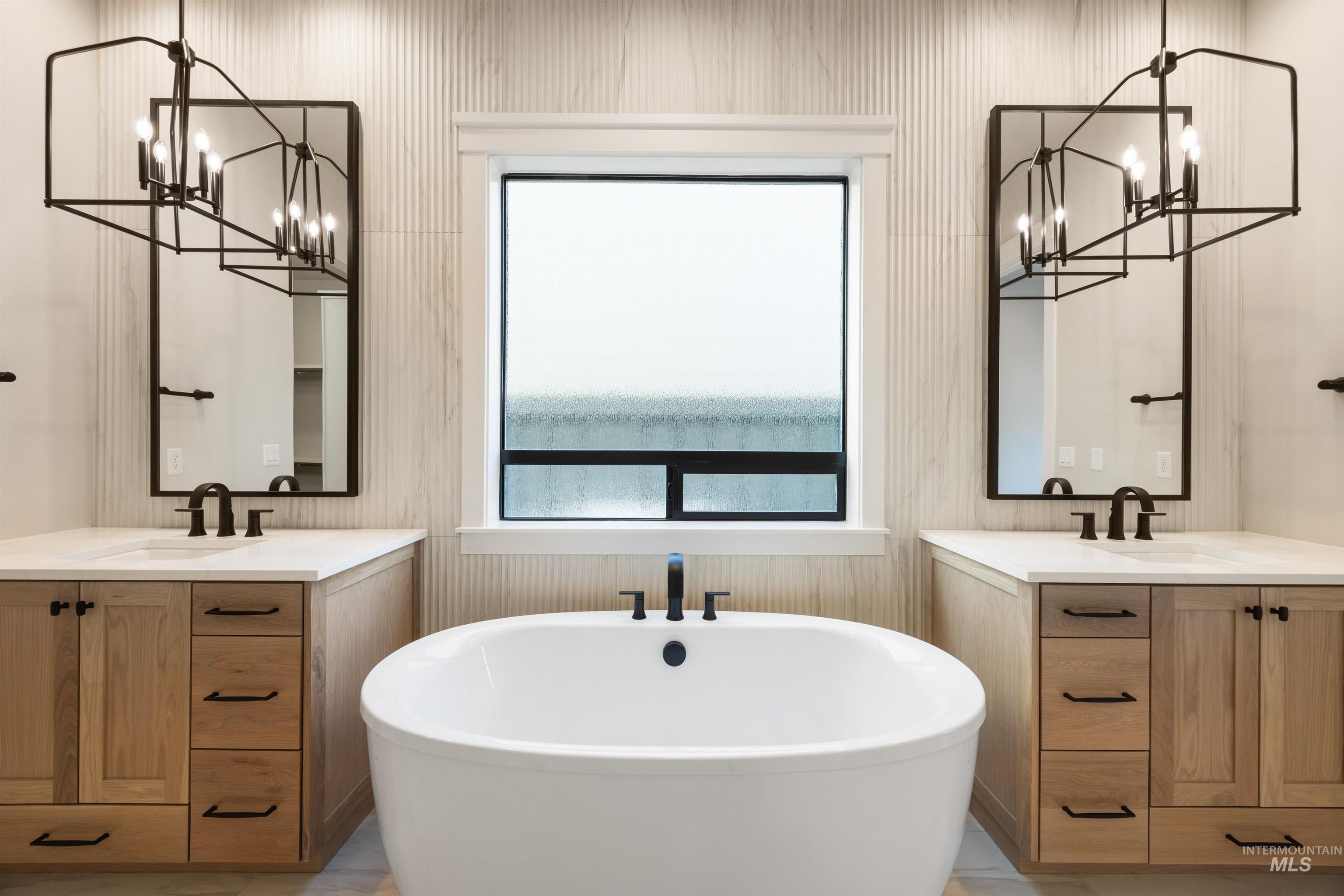 1048 East Escalation Street Meridian, ID 83642 - Photo 30 of 44 Bathroom featuring suspended lighting, two vanities, and a freestanding tub