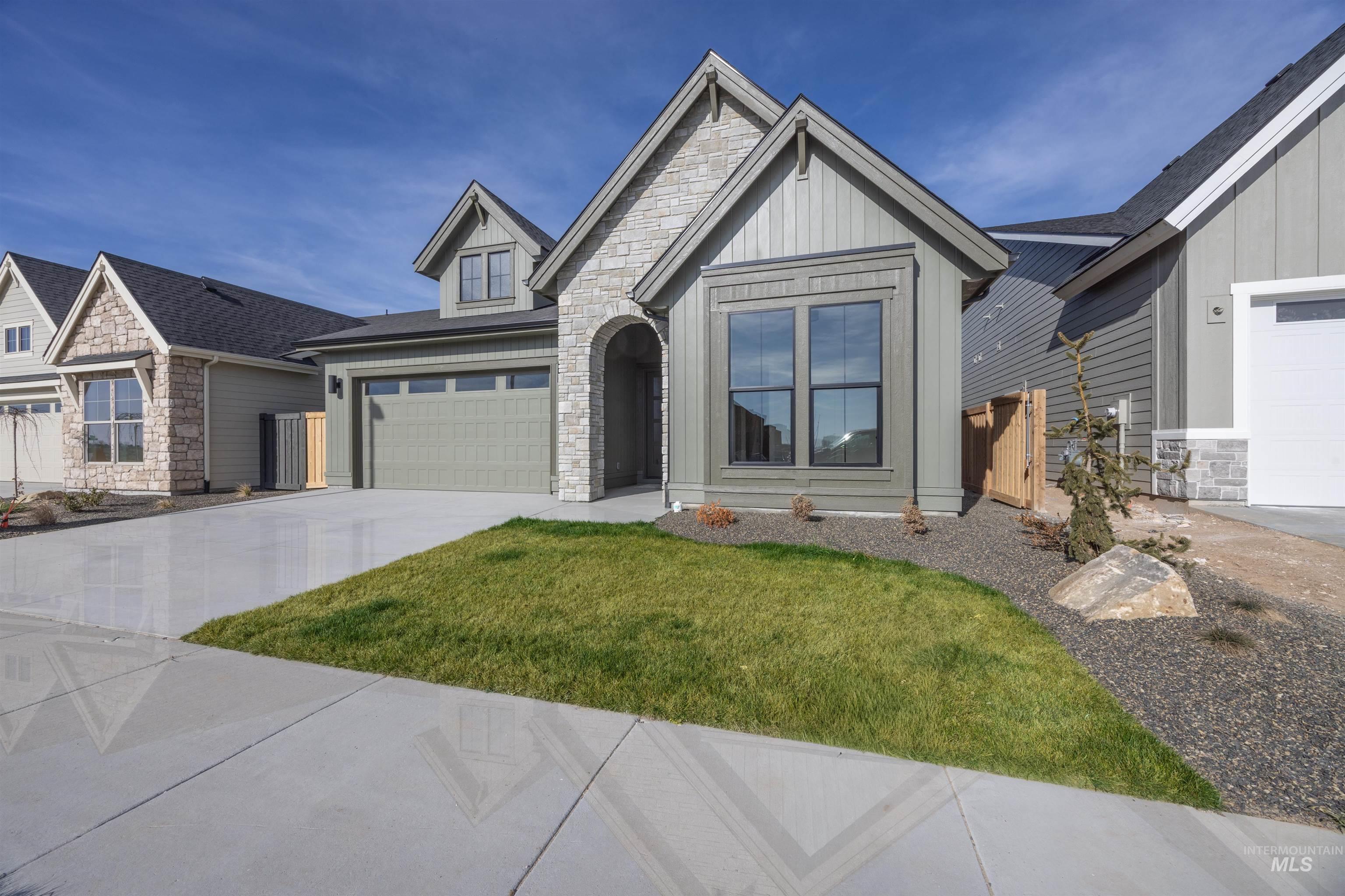 1048 East Escalation Street Meridian, ID 83642 - Photo 3 of 44 Craftsman-style house with stone siding, concrete driveway, board and batten siding, and an attached garage