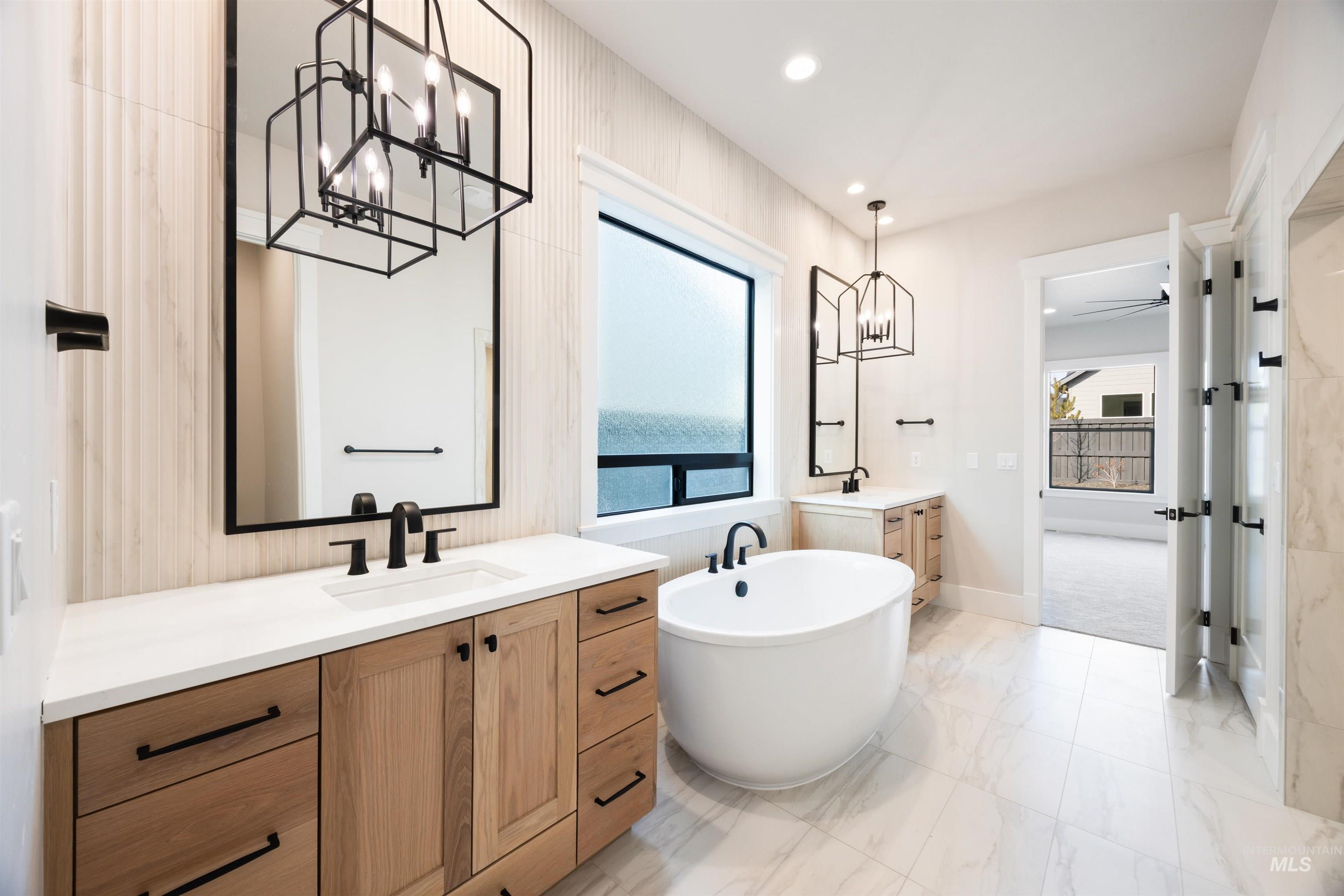 1048 East Escalation Street Meridian, ID 83642 - Photo 32 of 44 Bathroom with a chandelier, two vanities, a soaking tub, and healthy amount of natural light