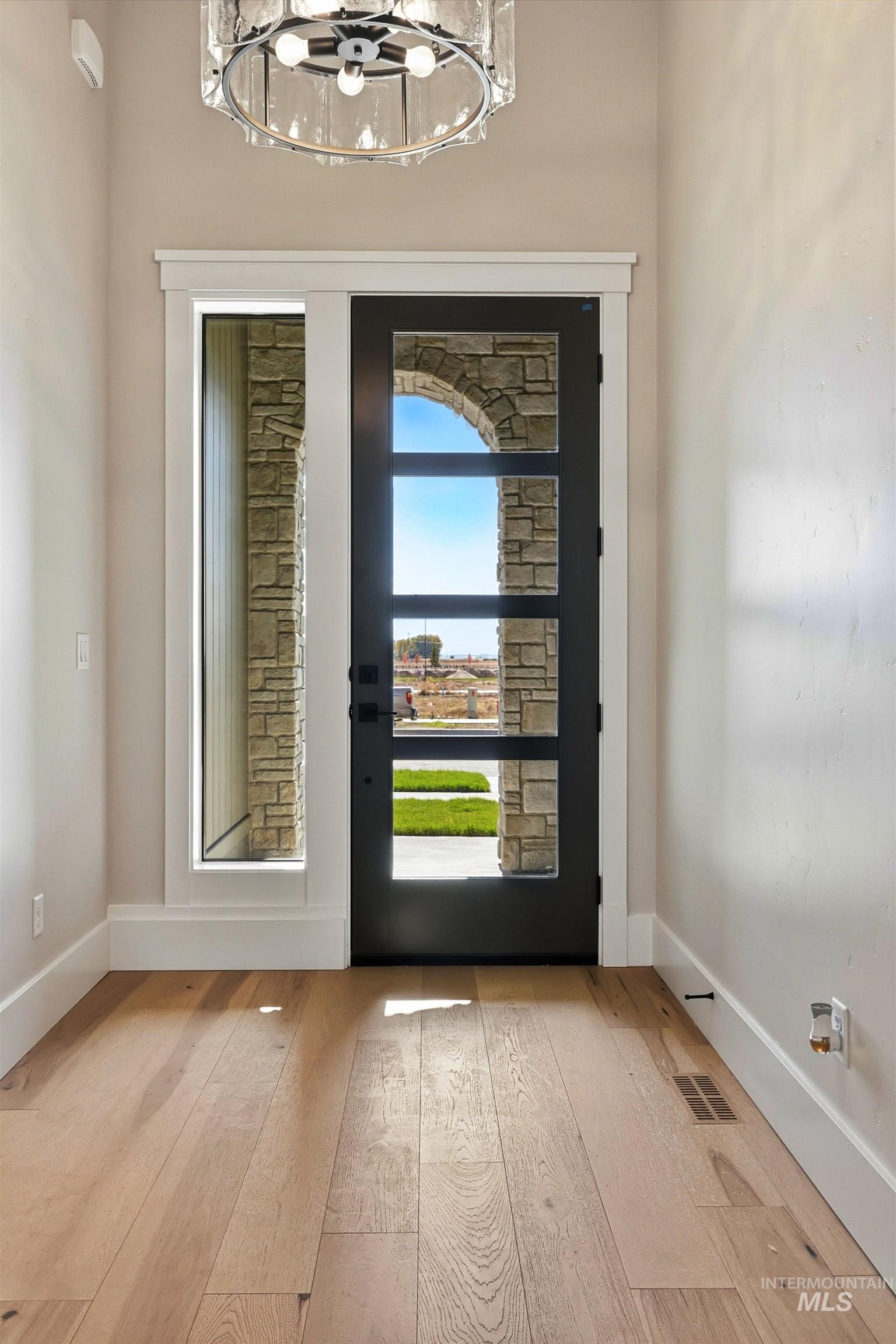 1048 East Escalation Street Meridian, ID 83642 - Photo 35 of 44 Doorway to outside featuring baseboards and wood-type flooring