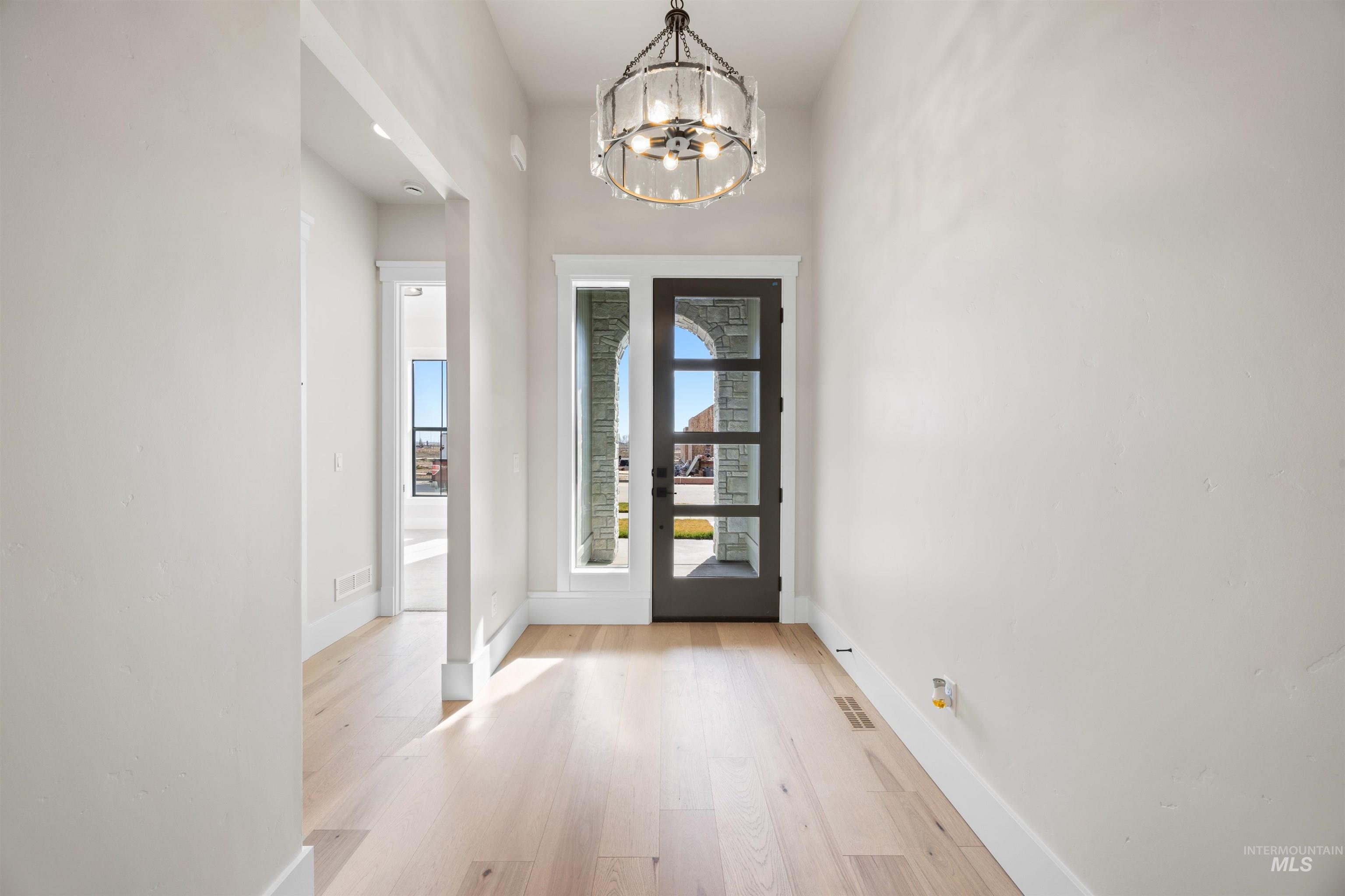 1048 East Escalation Street Meridian, ID 83642 - Photo 4 of 44 Foyer entrance featuring a chandelier and light wood-style floors