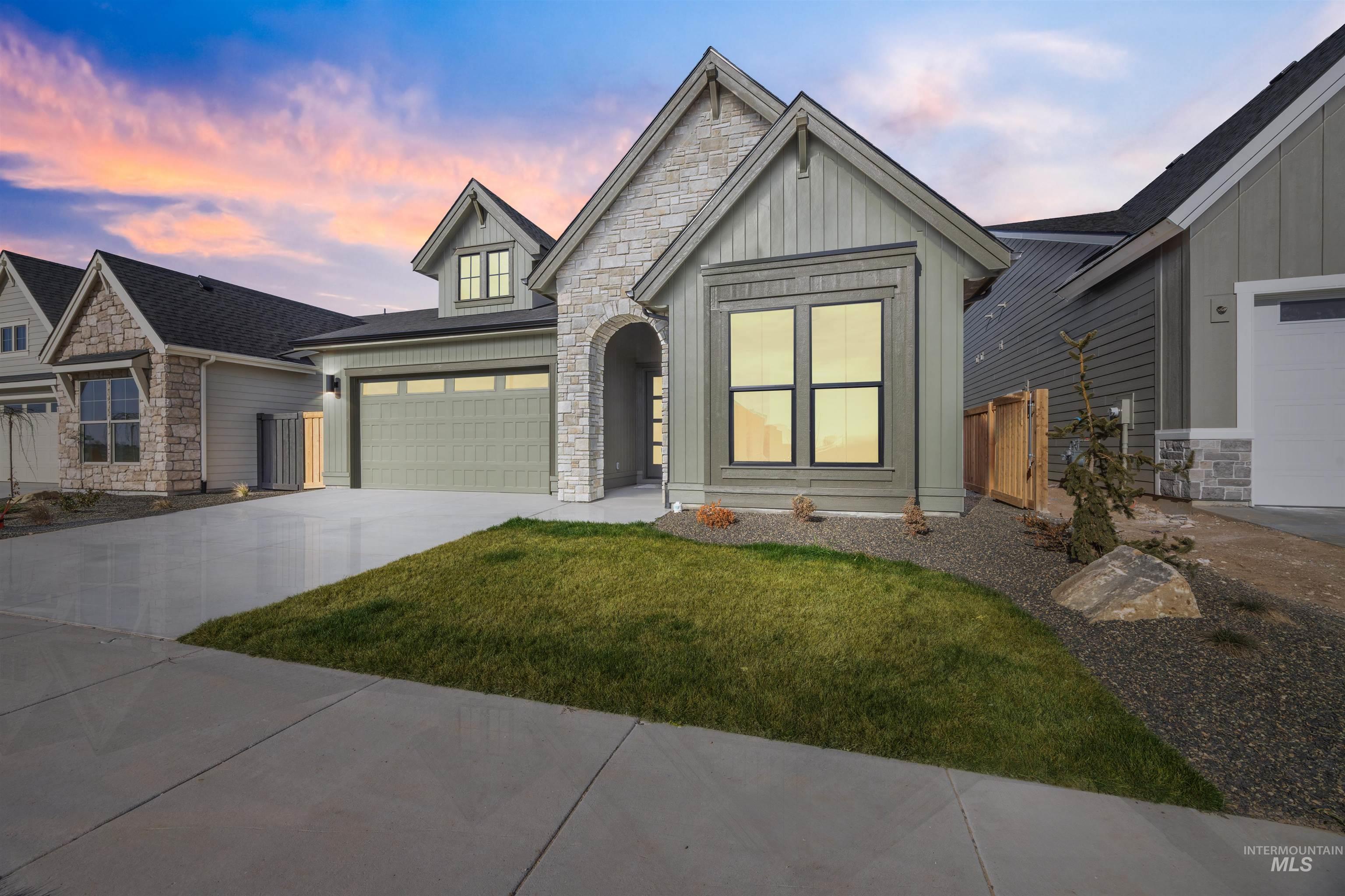 1048 East Escalation Street Meridian, ID 83642 - Photo 44 of 44 View of front of home featuring stone siding, board and batten siding, concrete driveway, and an attached garage