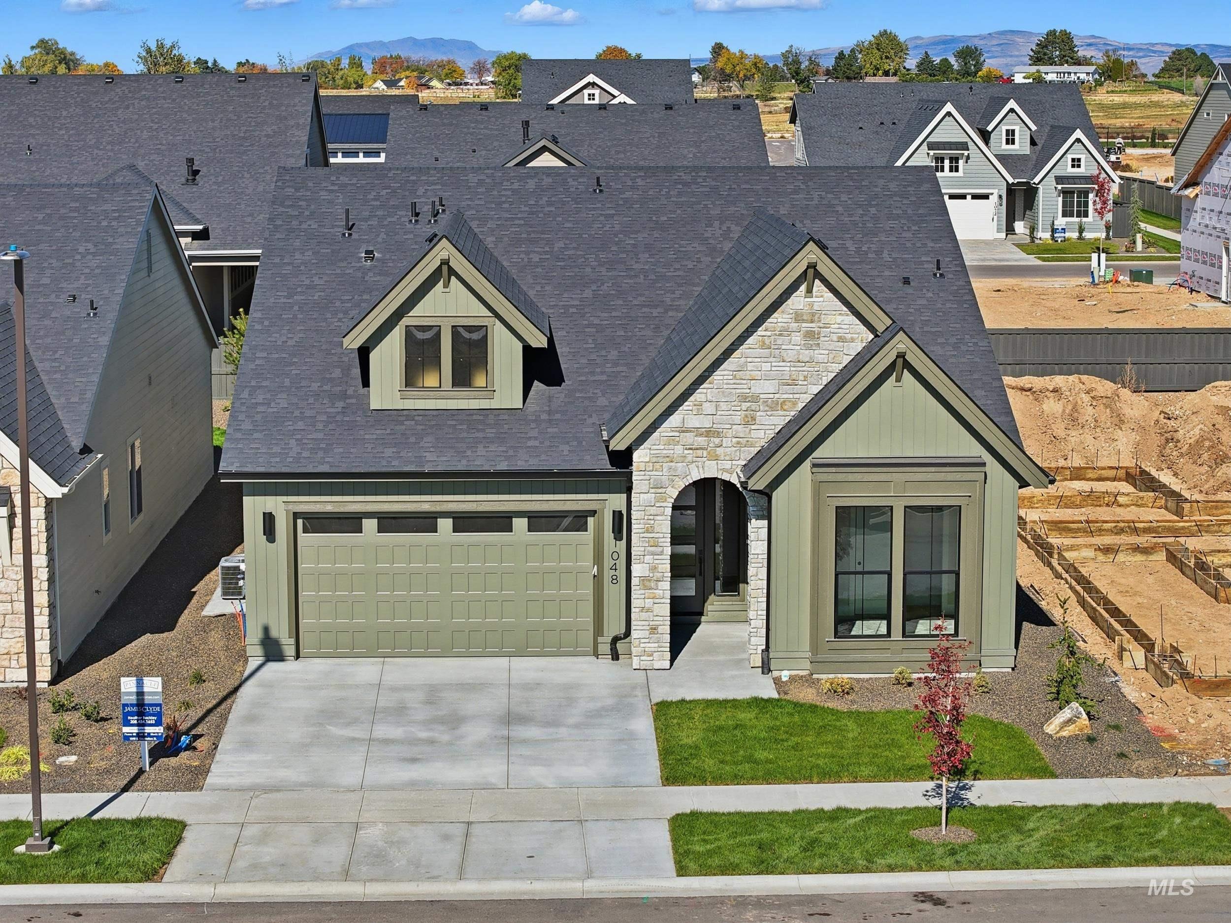 1048 East Escalation Street Meridian, ID 83642 - Photo 44 of 44 View of front of property with stone siding, driveway, an attached garage, roof with shingles, and a residential view