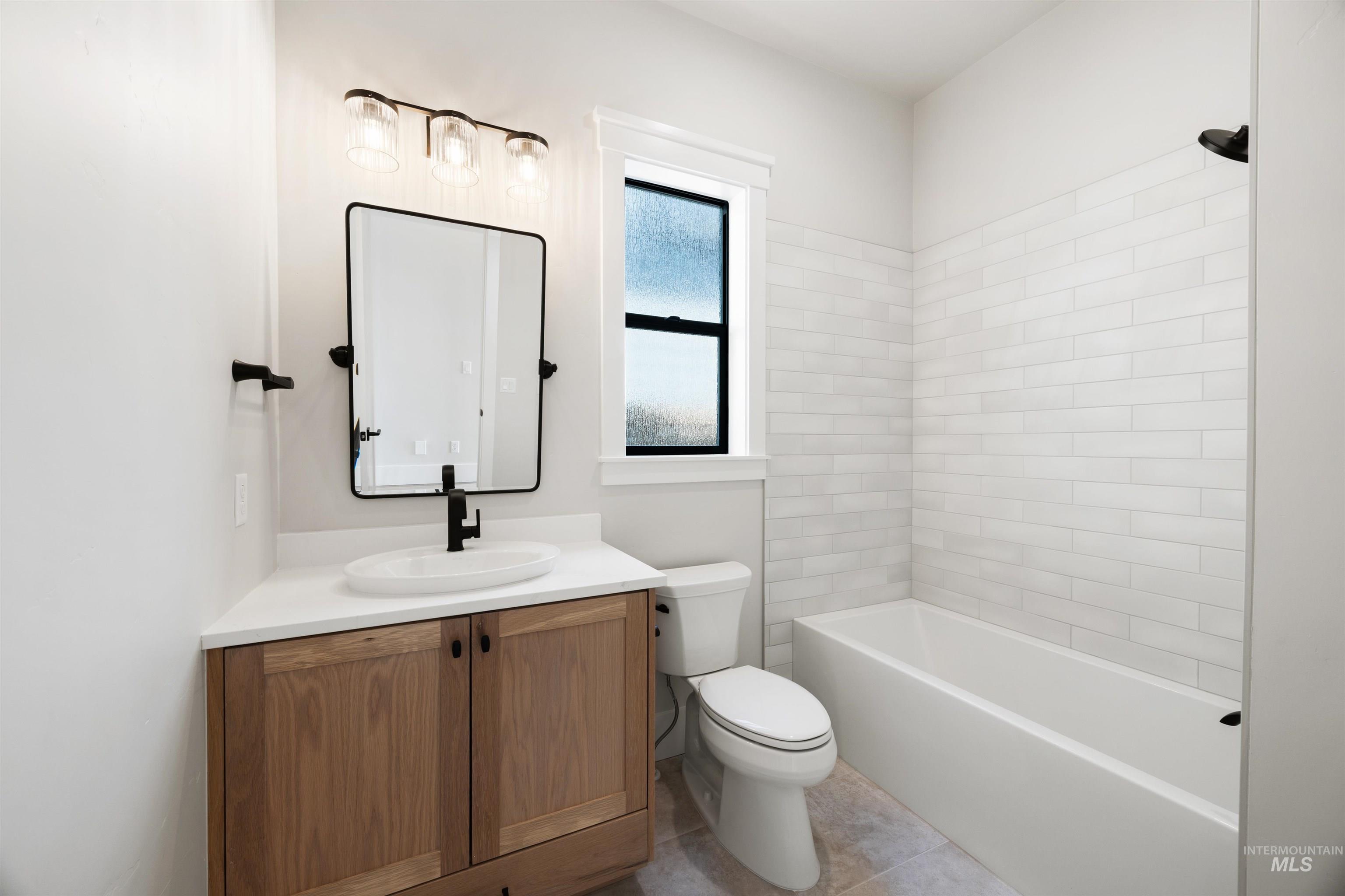 1048 East Escalation Street Meridian, ID 83642 - Photo 7 of 44 Full bath featuring vanity, bathtub / shower combination, and light tile patterned floors