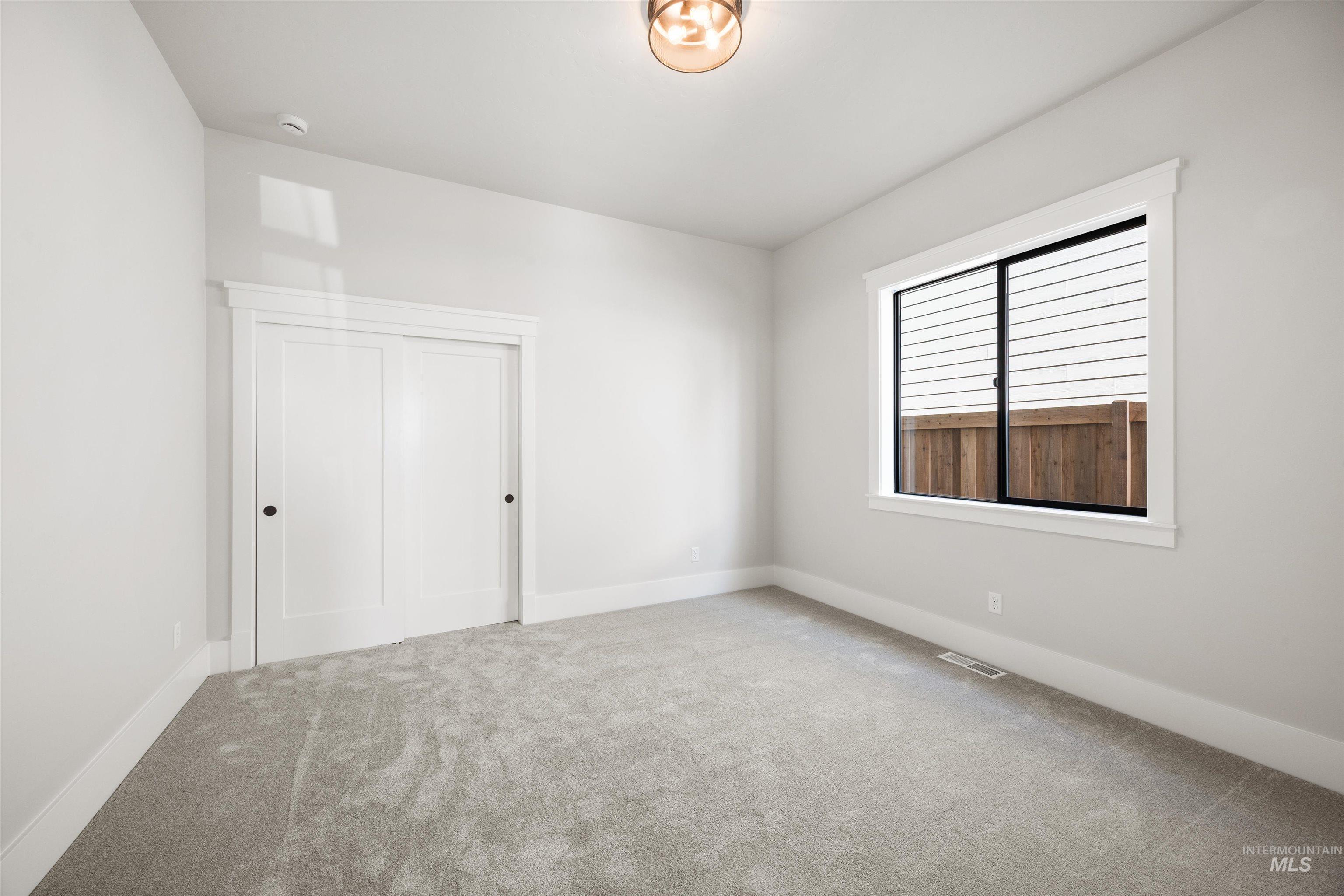 1048 East Escalation Street Meridian, ID 83642 - Photo 8 of 44 Unfurnished bedroom with light carpet and baseboards
