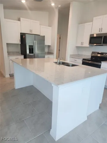 a kitchen with stainless steel appliances a sink stove and refrigerator