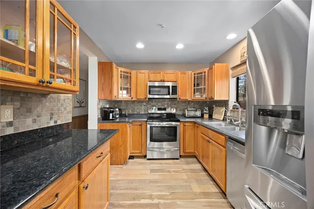 a kitchen with stainless steel appliances granite countertop wooden cabinets a sink and a stove
