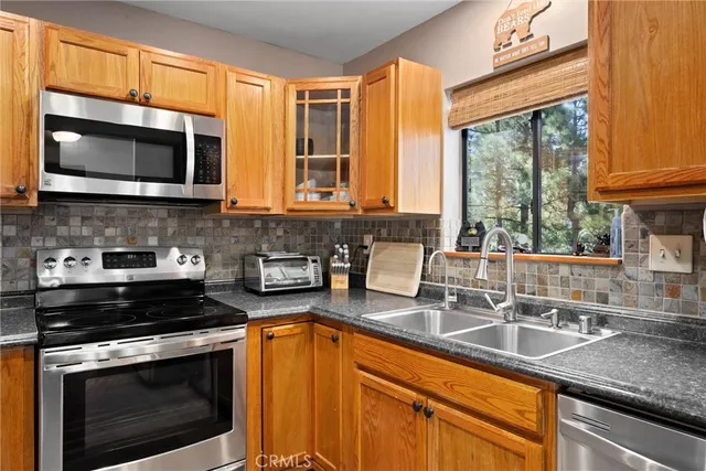 a kitchen with stainless steel appliances a stove sink and microwave
