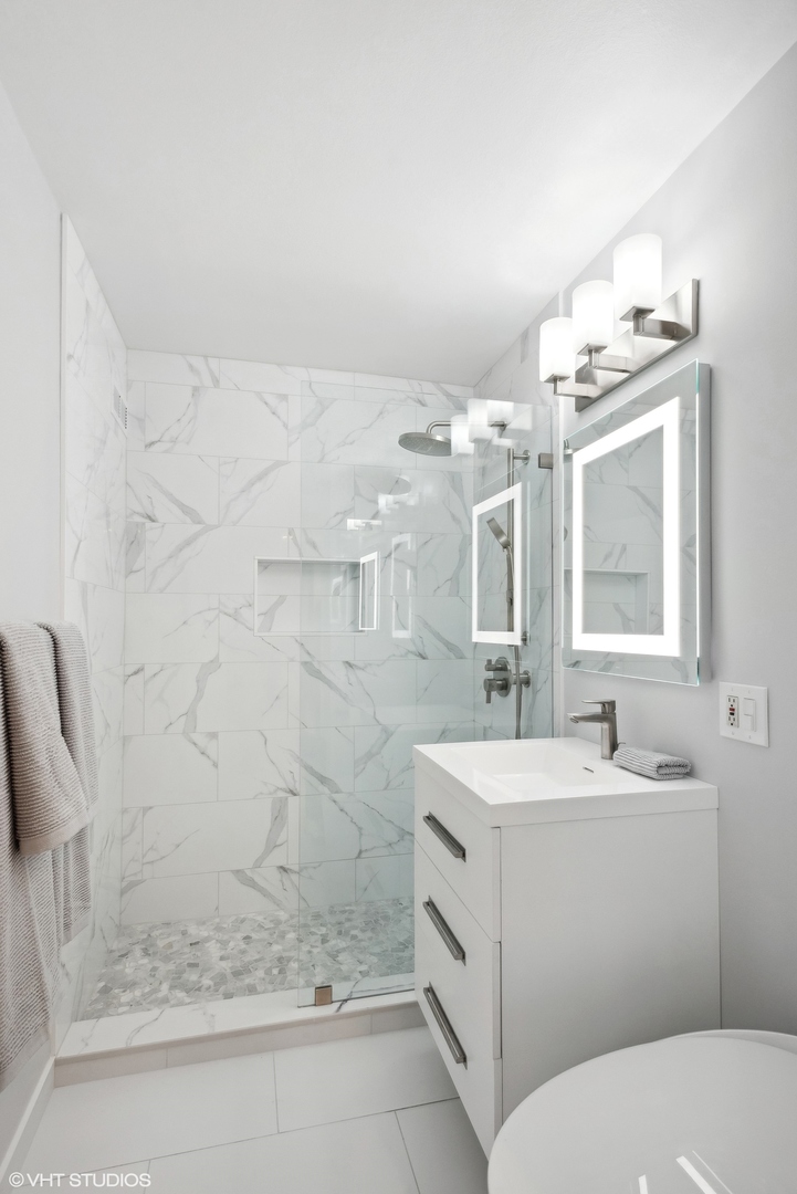 1150 North Lake Shore Drive, Unit 4H Chicago, IL 60611 - Photo 14 of 18 a bathroom with a sink a toilet and shower