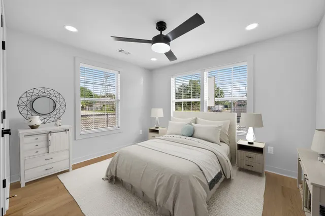 a spacious bedroom with a large bed and a chandelier