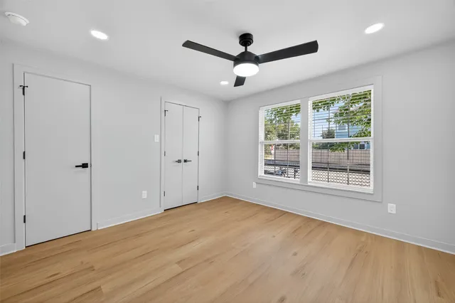 a view of empty room with wooden floor and ceiling fan