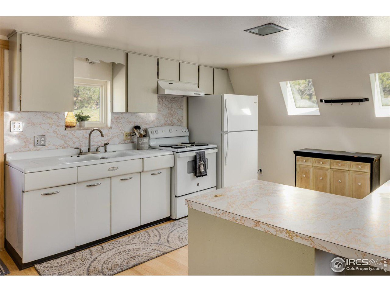 5690 Sugarloaf Road Boulder, CO 80302 - Photo 13 of 27 a kitchen with a sink a refrigerator and cabinets