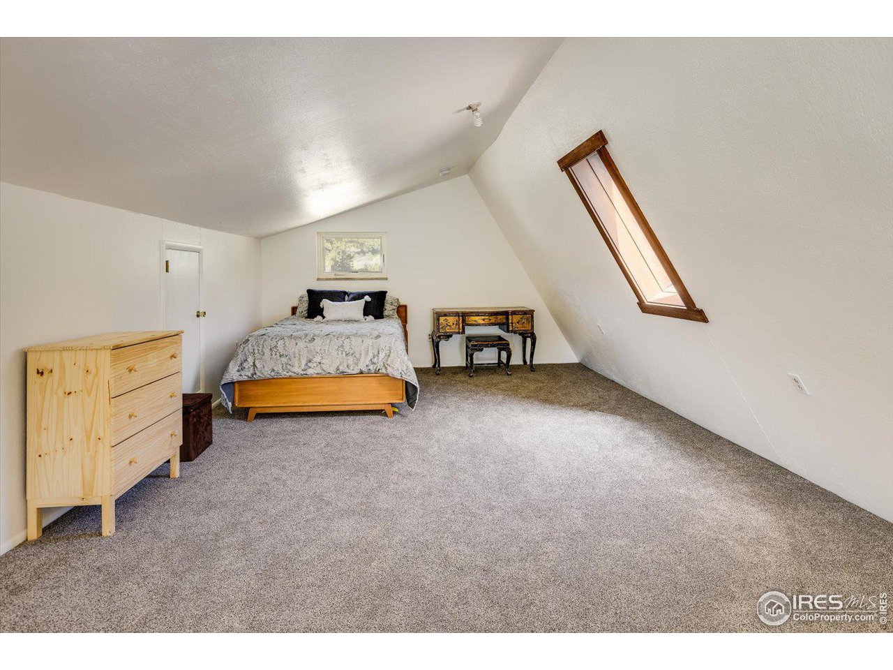 5690 Sugarloaf Road Boulder, CO 80302 - Photo 18 of 27 a spacious bedroom with a bed and a chandelier