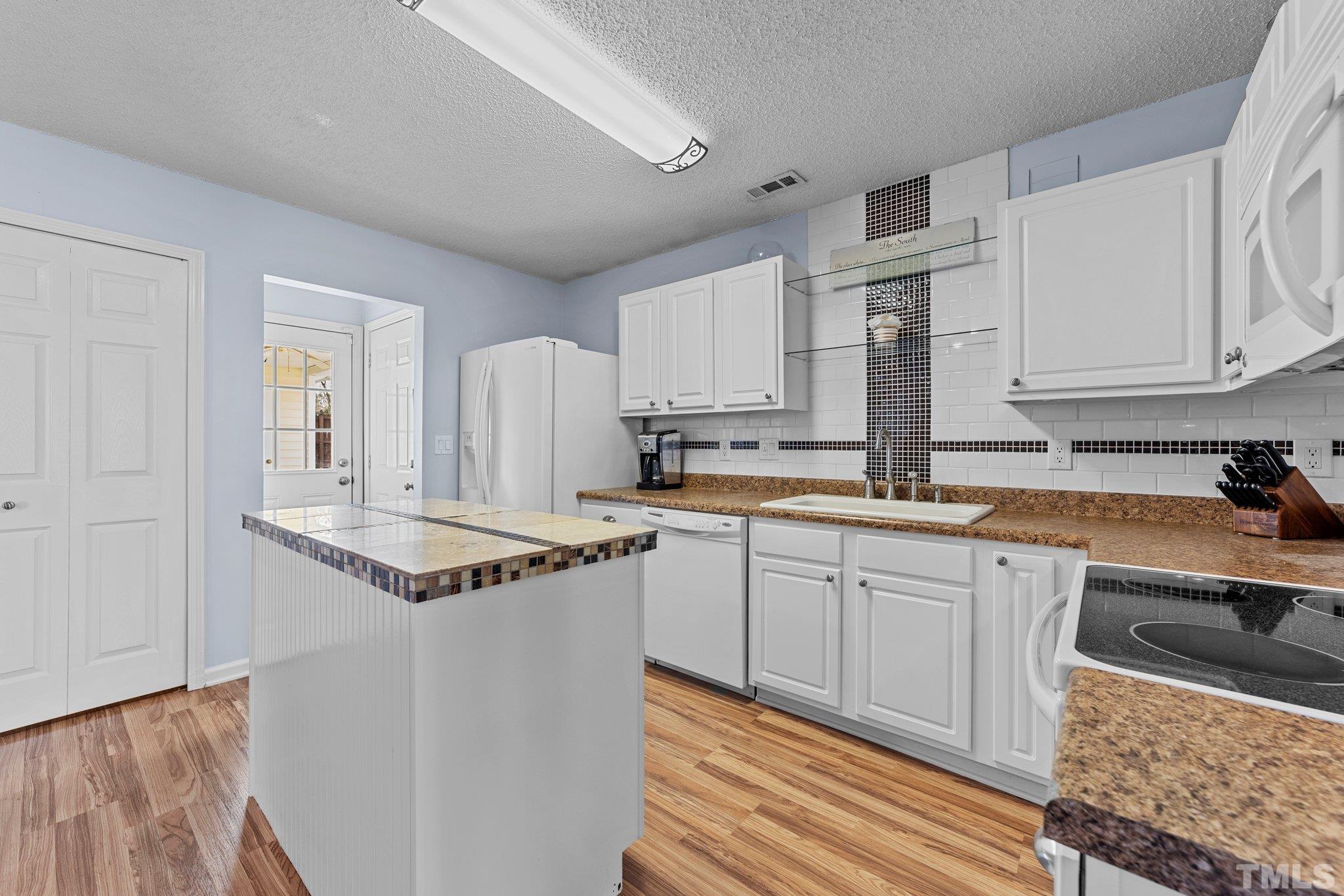 5022 Silhouette Drive Durham, NC 27713 - Photo 11 of 26 a kitchen with stainless steel appliances granite countertop a sink stove and cabinets