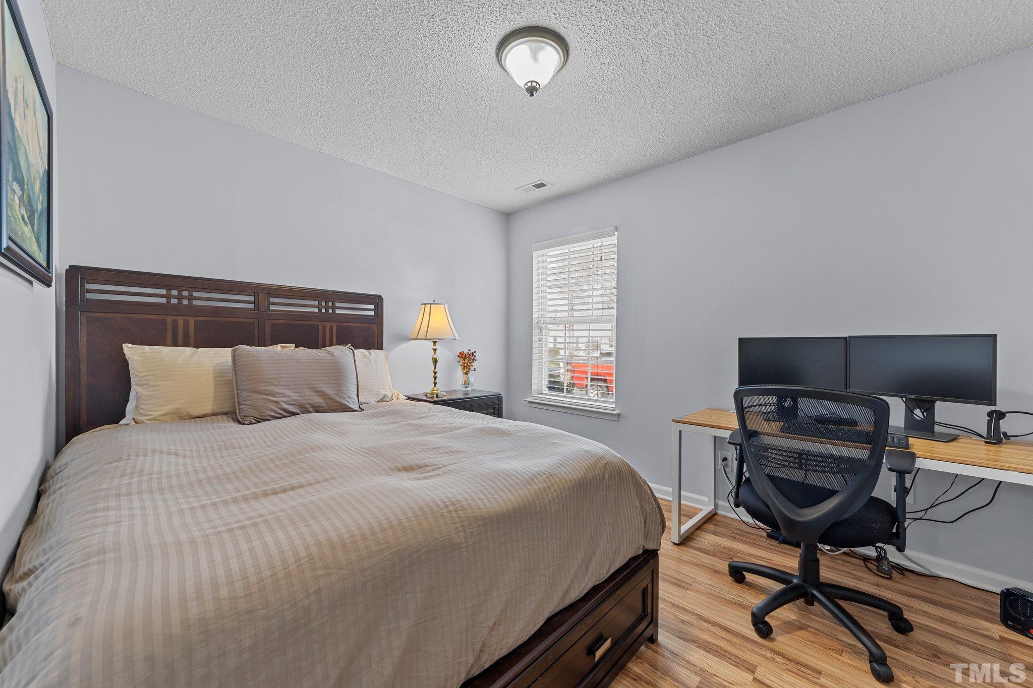 5022 Silhouette Drive Durham, NC 27713 - Photo 15 of 26 a bedroom with a bed and a chair in it