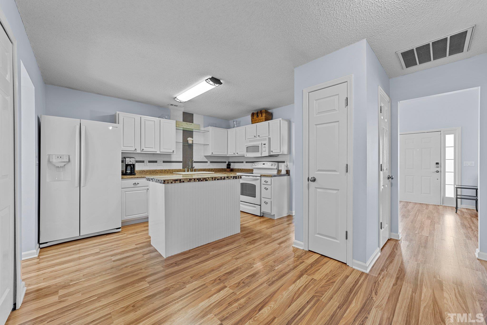 5022 Silhouette Drive Durham, NC 27713 - Photo 8 of 26 a kitchen with cabinets and wooden floor