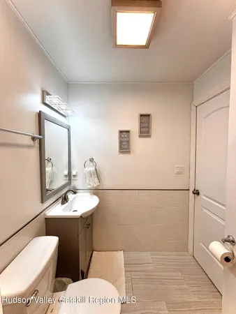 a bathroom with a toilet a sink and mirror