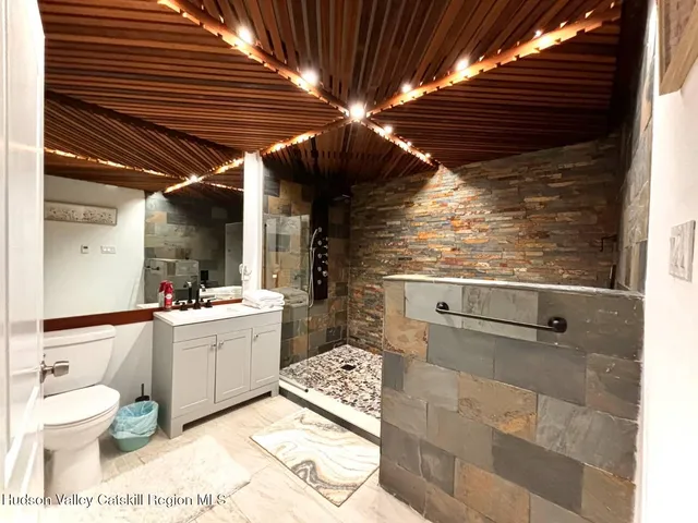 a bathroom with a sink a toilet and shower