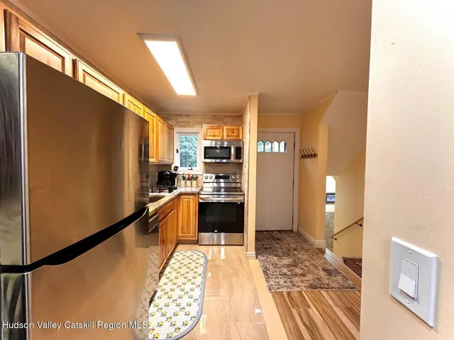 a kitchen with granite countertop stainless steel appliances a refrigerator and cabinets
