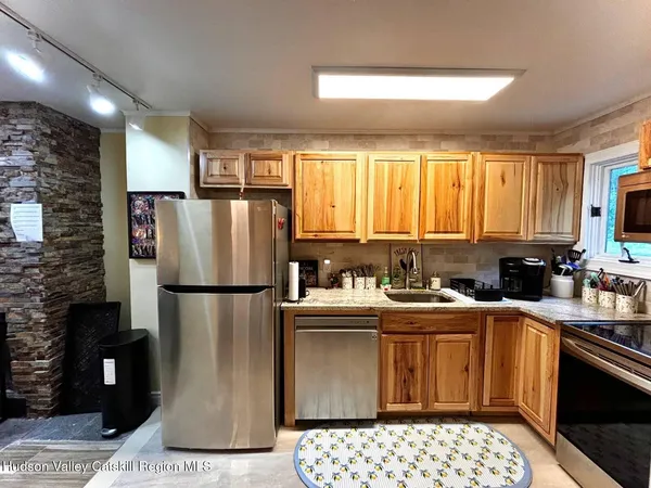 a kitchen with a sink a refrigerator a window and cabinets