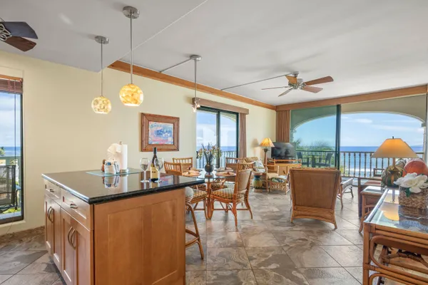 a dining hall with furniture kitchen view and a large window