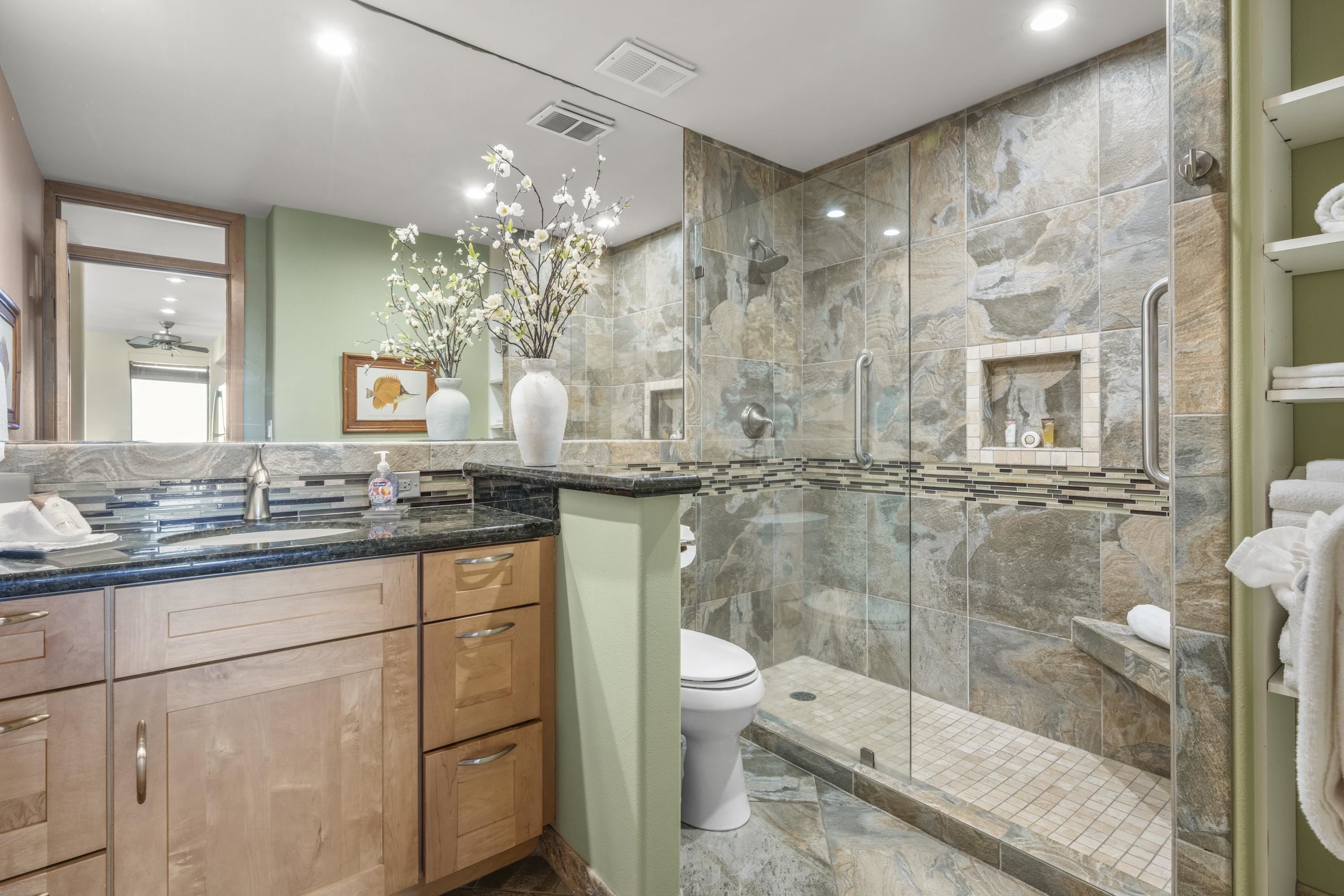 475 Front Street, Unit 601 Lahaina, HI 96761 - Photo 21 of 24 a bathroom with a granite countertop sink a toilet and a shower