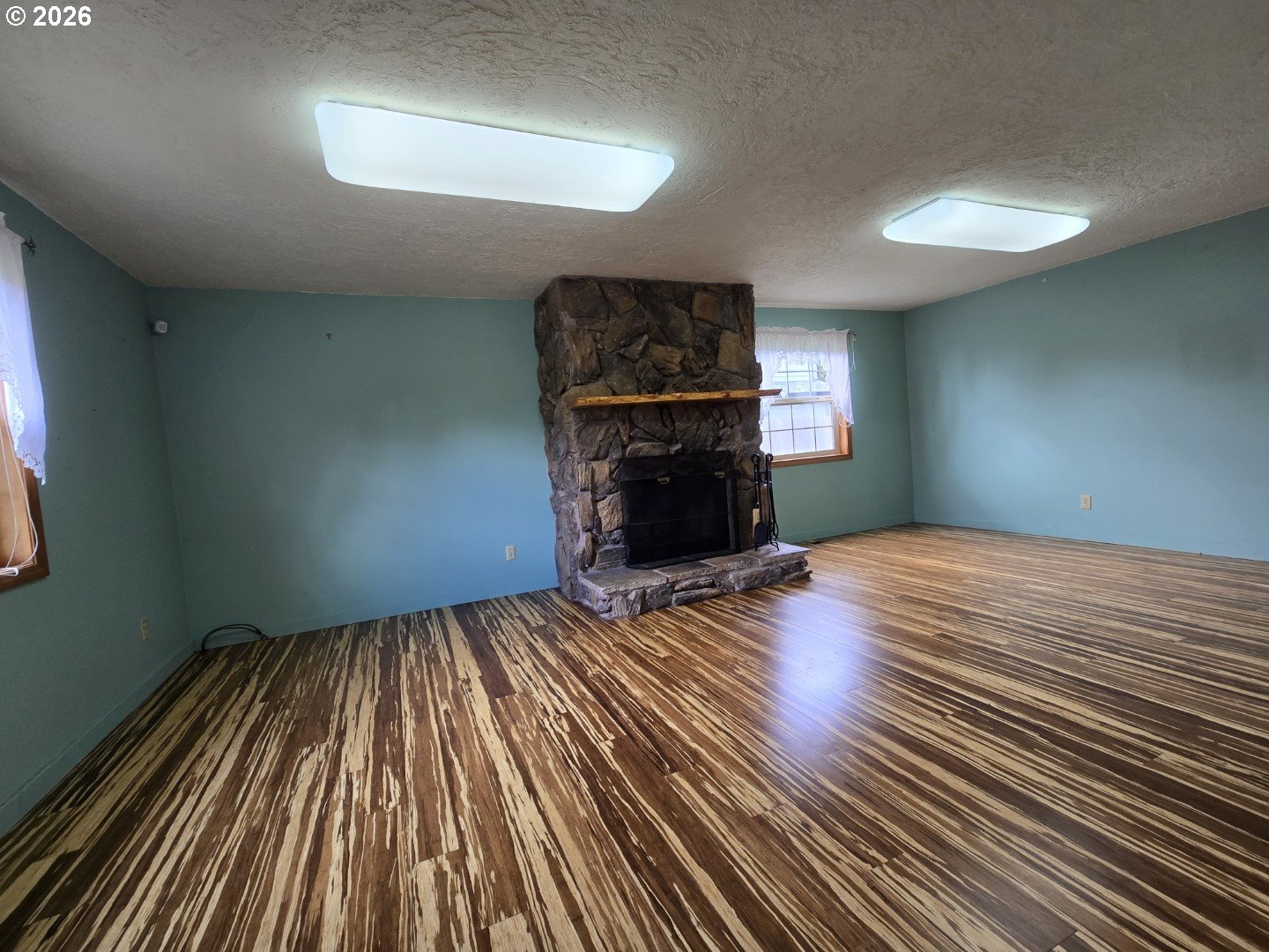 2633 42nd Avenue Longview, WA 98632 - Photo 18 of 32 wooden floor in an empty room with a fireplace